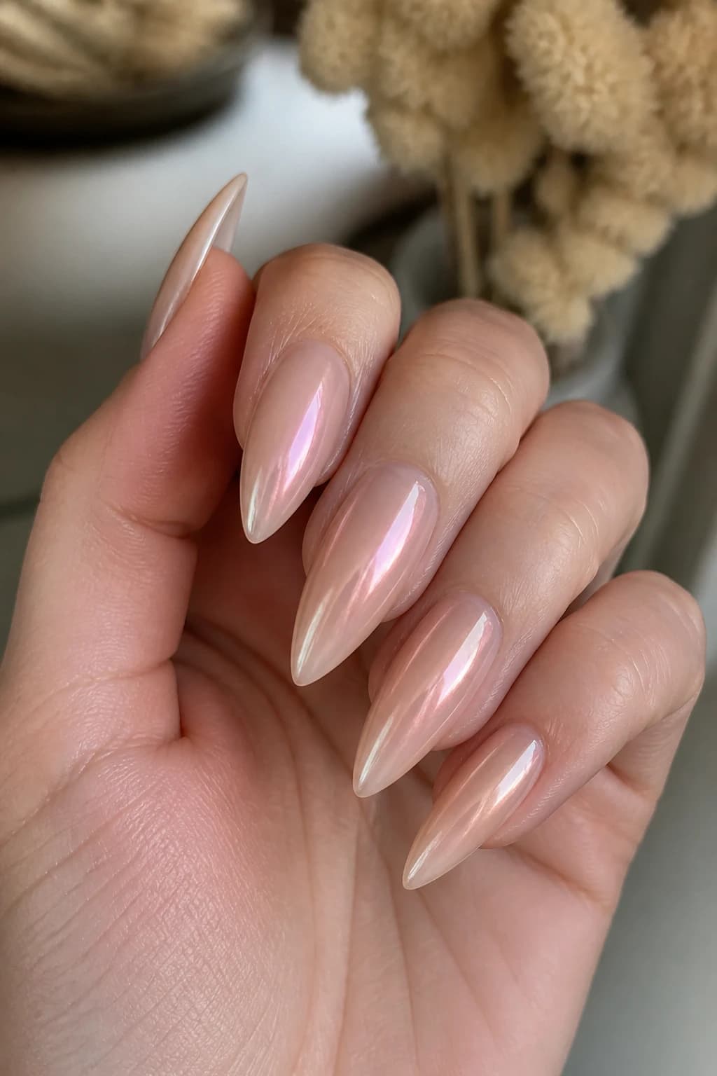 Long stiletto nails in nude with an aura design and a chrome finish