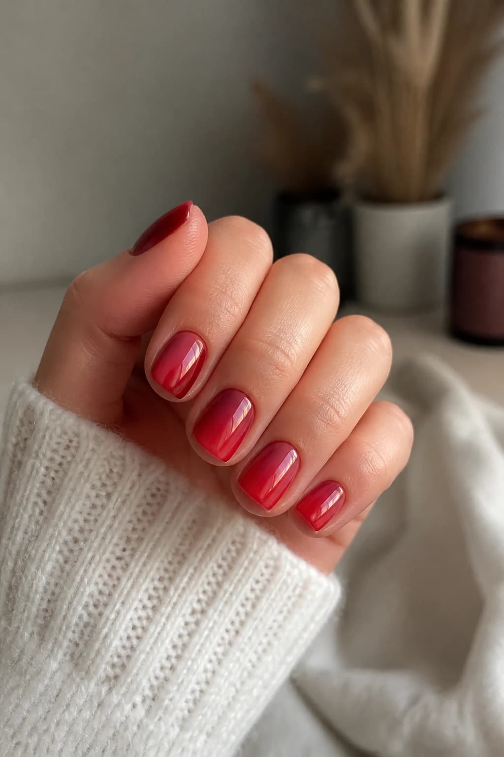 Short oval nails in red with an aura design and a chrome finish