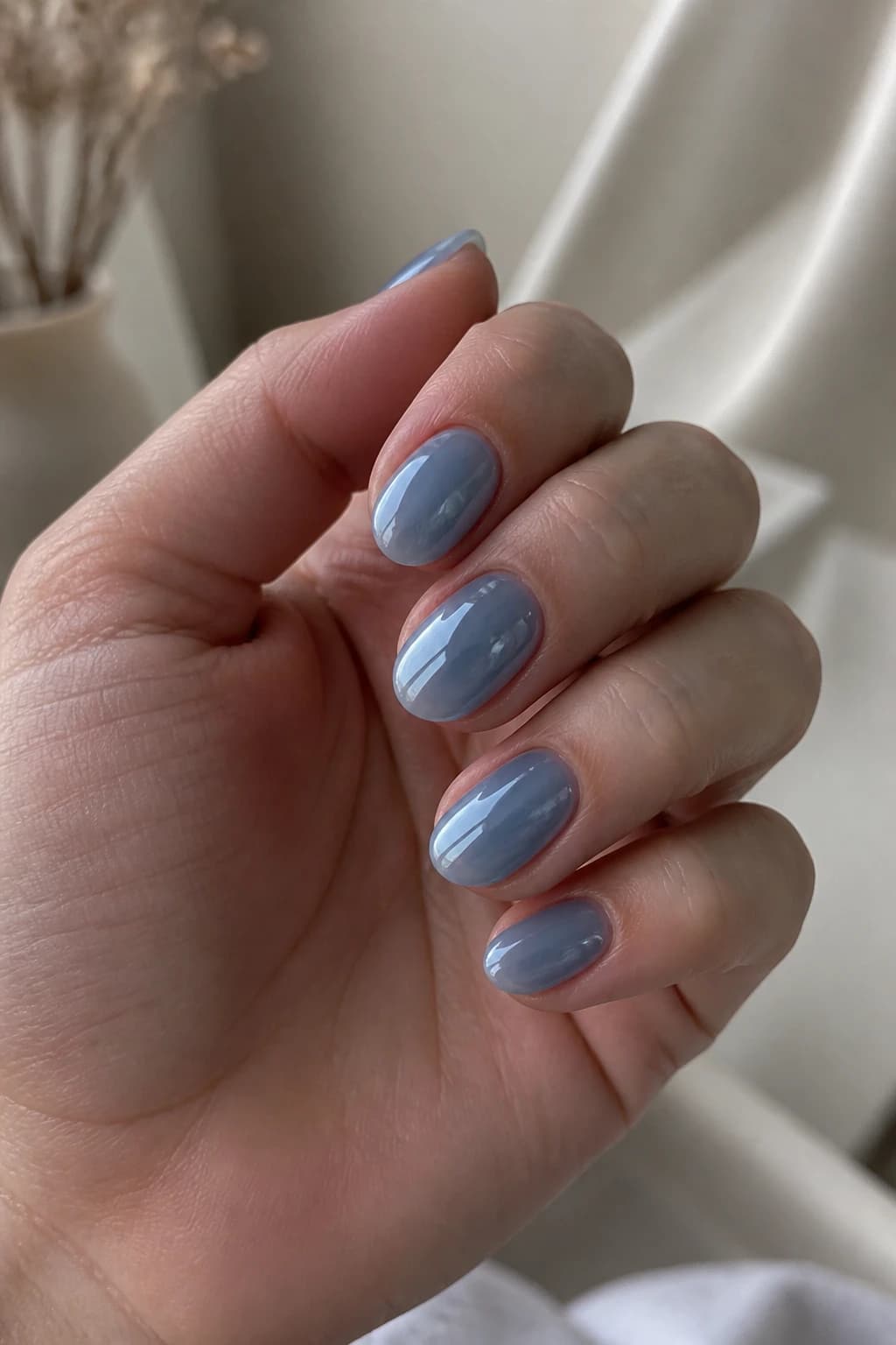 Short almond nails in blue with a jelly design and a chrome finish