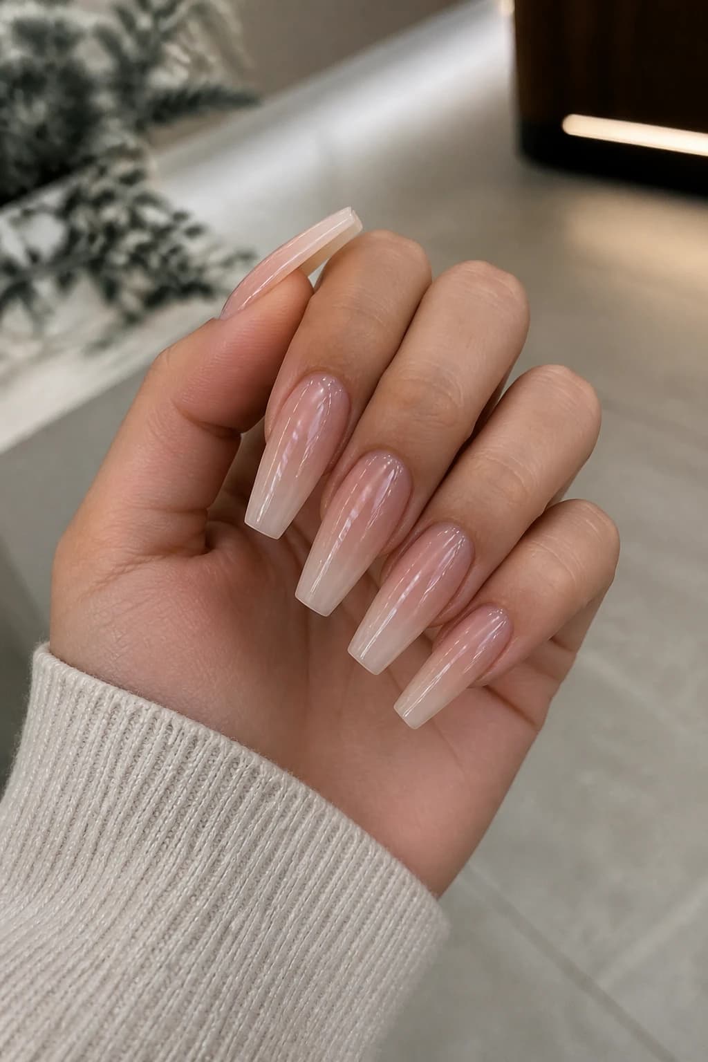 Long coffin nails in nude with an ombré design and a chrome finish