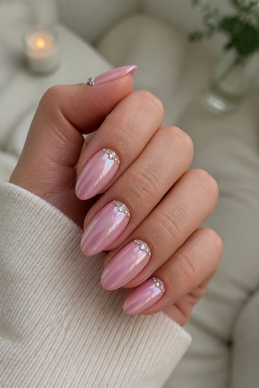 Long almond nails in pink with a rhinestone design and a chrome finish
