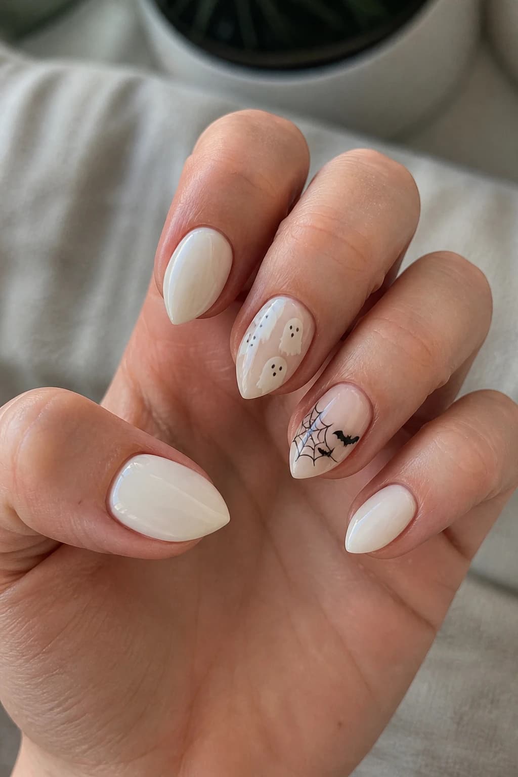 Short stiletto nails in white and cream with a glossy finish, Halloween nail design