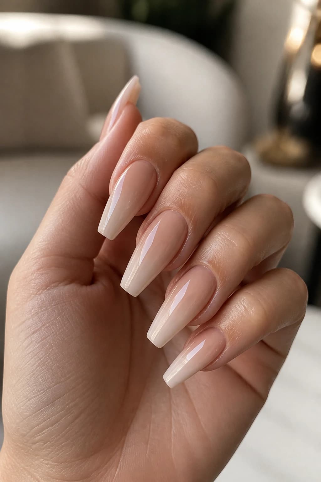 Long coffin nails in nude with an ombré design and a glossy finish