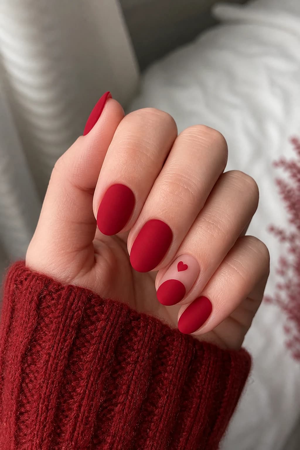 Short almond nails in red with a heart design and a matte finish, fall nail design