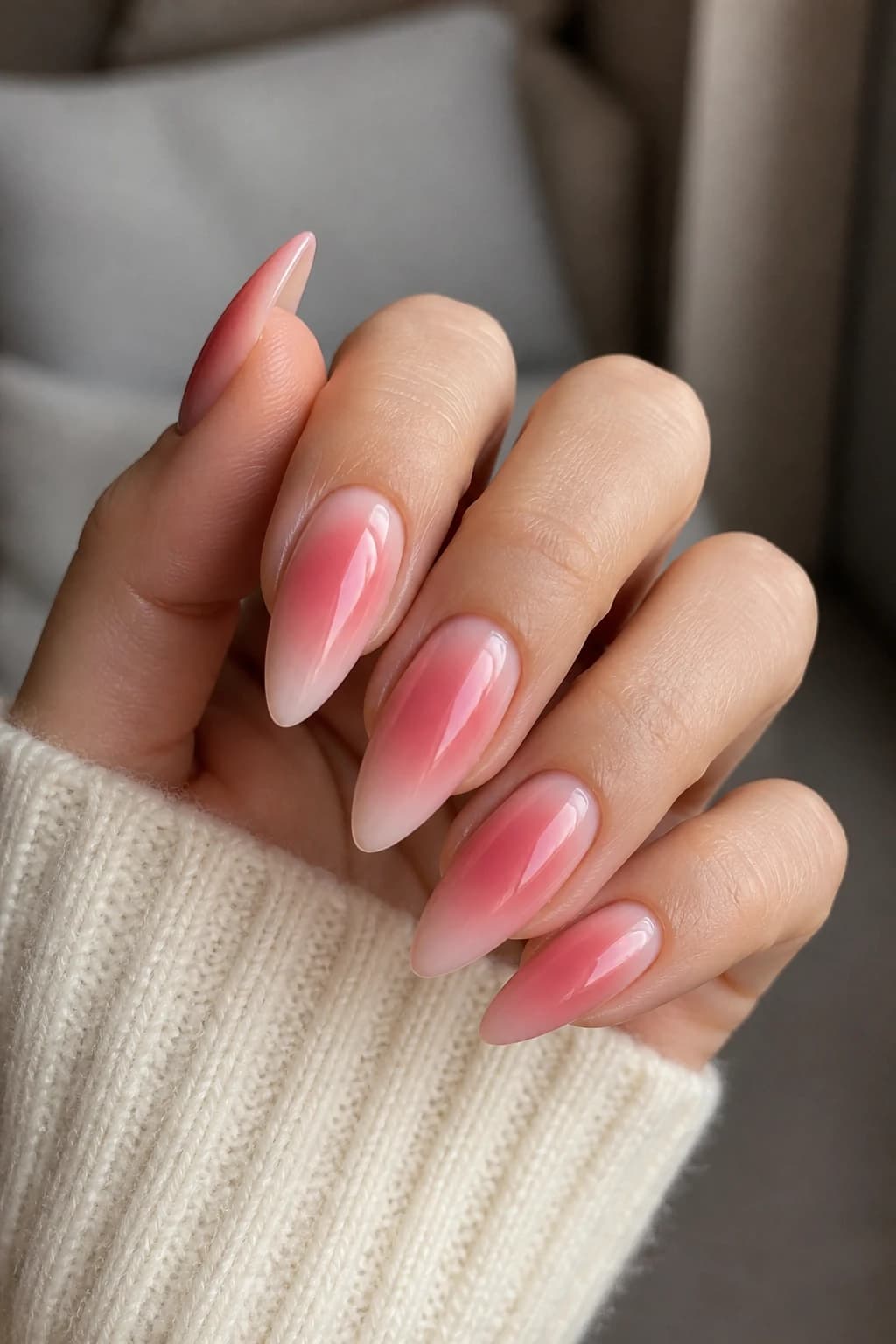 Long almond nails in pink with an aura design and a glossy finish