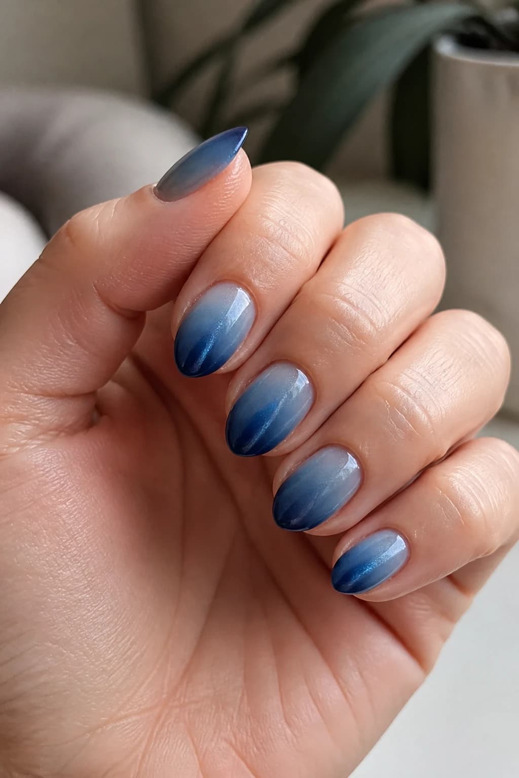 Short stiletto nails in blue with an ombré design and a cat eye finish