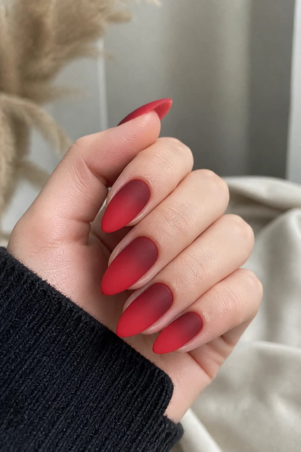 Long almond nails in red with an ombré design and a matte finish