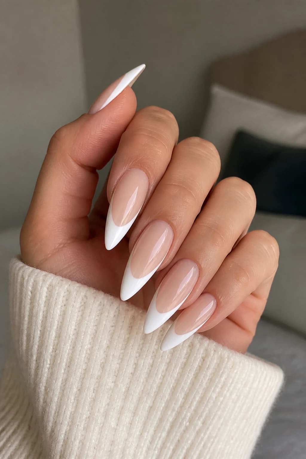 Long stiletto nails in white and cream with a French tip design and a glossy finish