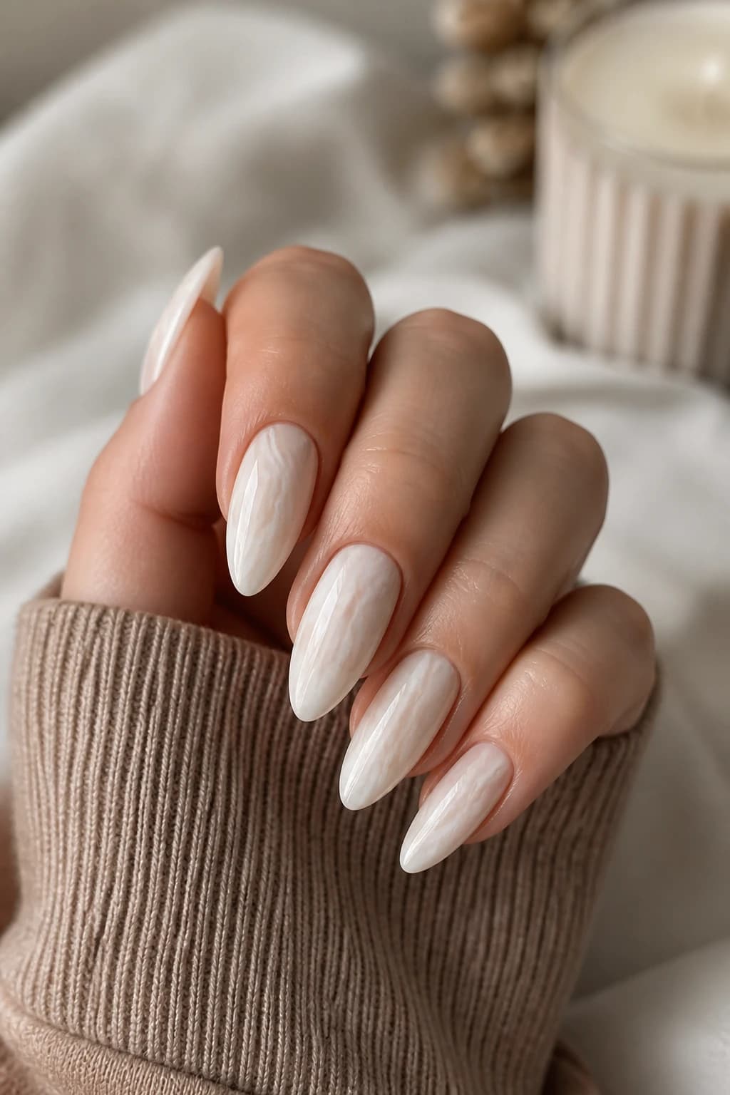 Long almond nails in white and cream with a marble design and a glossy finish