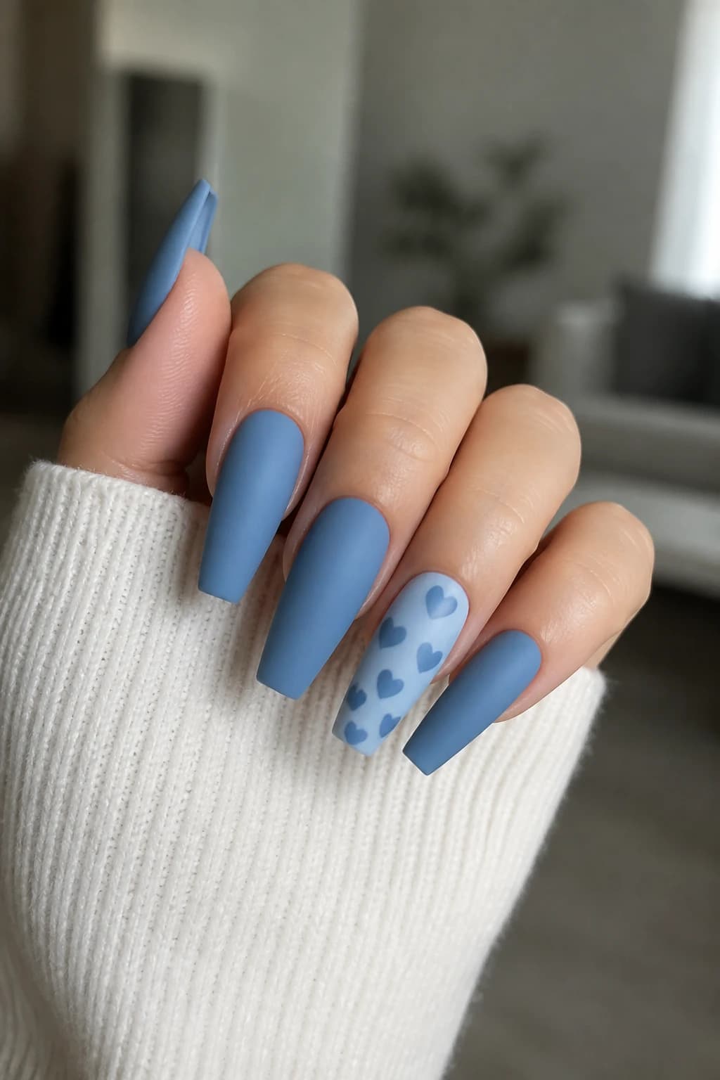 Long coffin nails in blue with a heart design and a matte finish