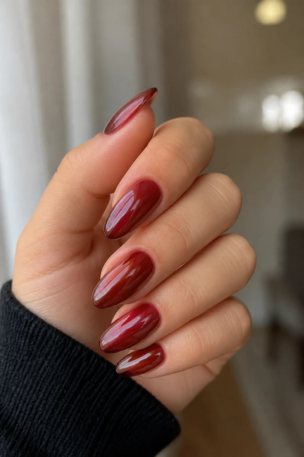 Long almond nails in red with a jelly design and a chrome finish, fall nail design