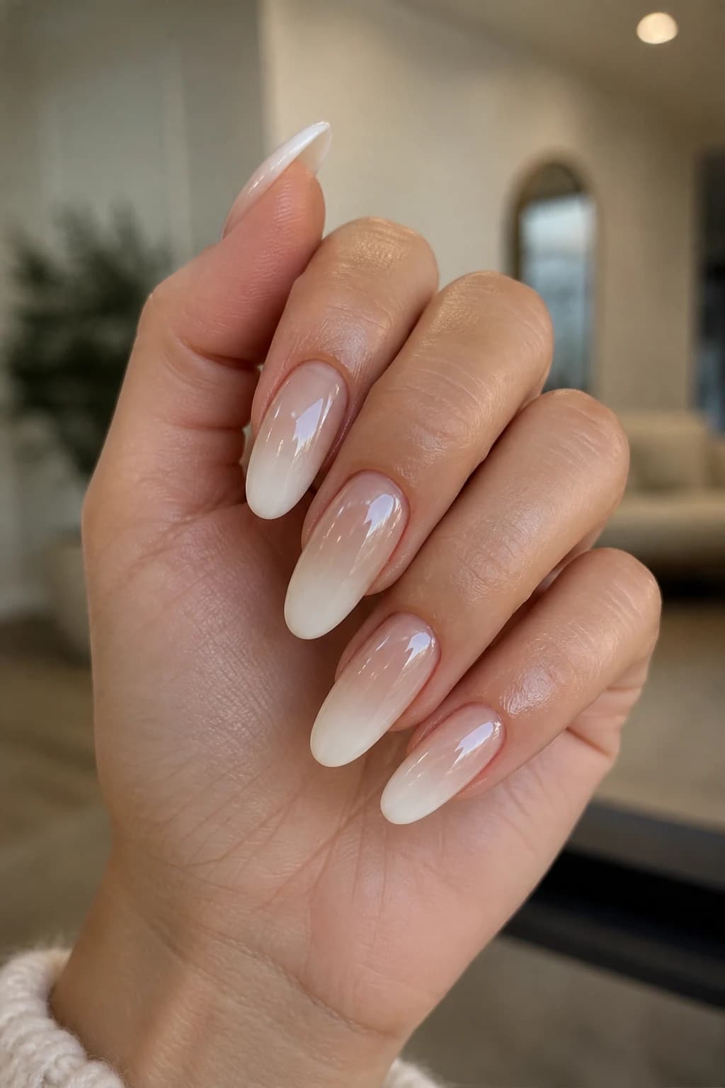 Long round nails in white and cream with an ombré design and a chrome finish, fall nail design