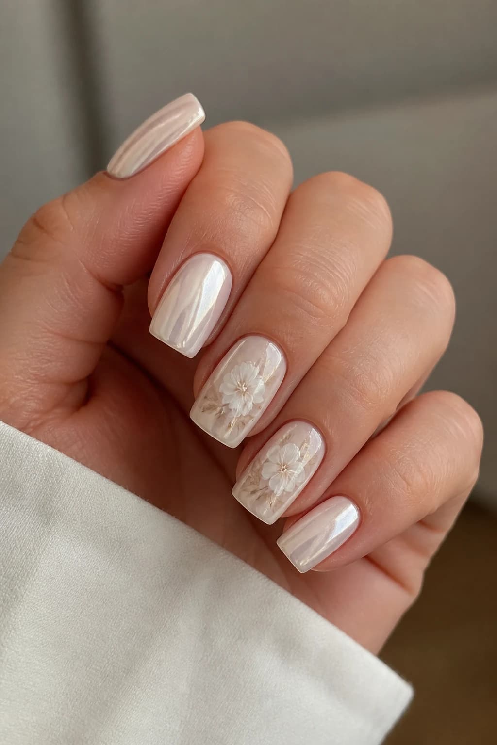 Medium square nails in white and cream with a floral design and a chrome finish, fall nail design