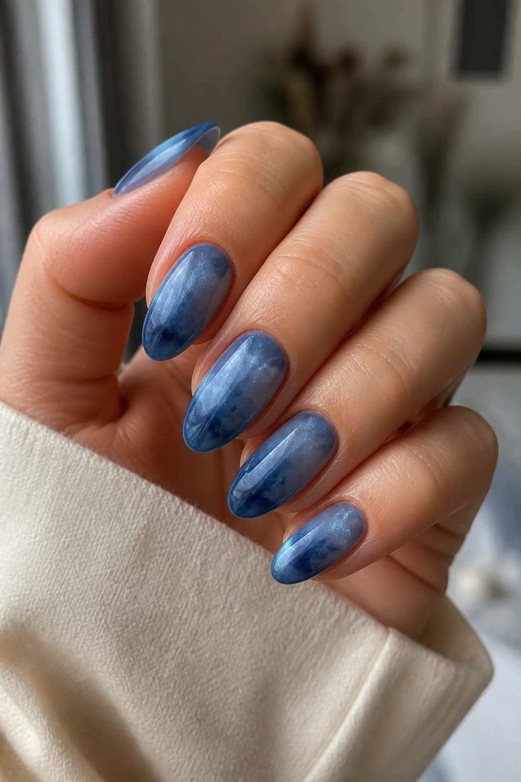 Long almond nails in blue with a blooming gel design and a cat eye finish, fall nail design