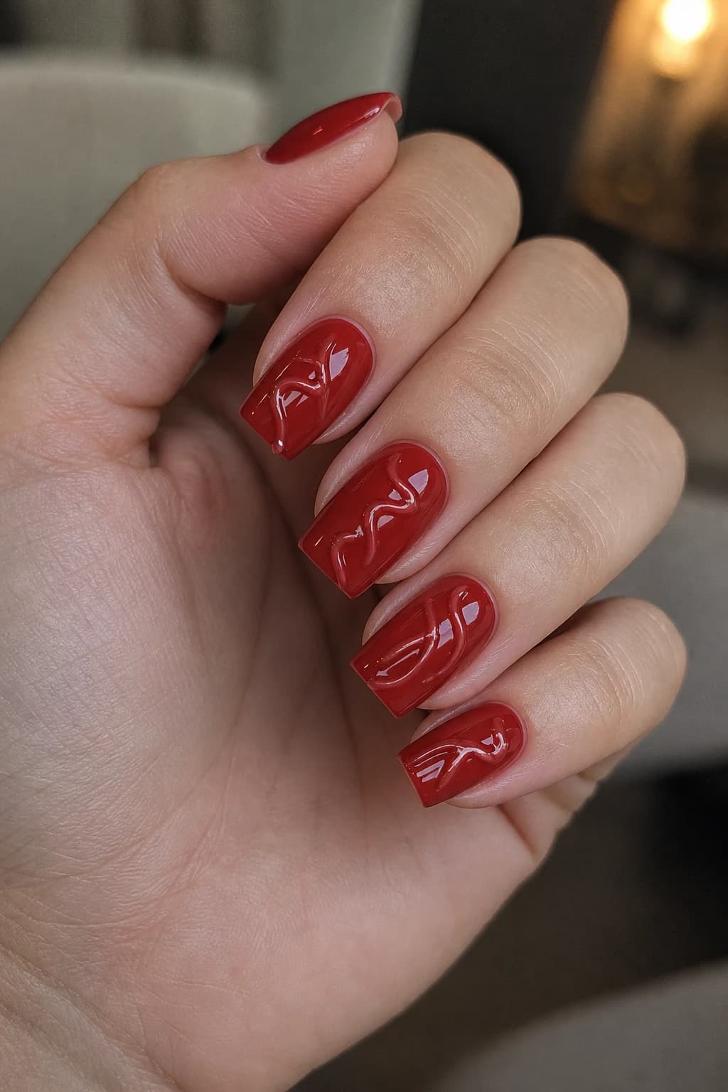 Short coffin nails in red with a 3D design and a glossy finish