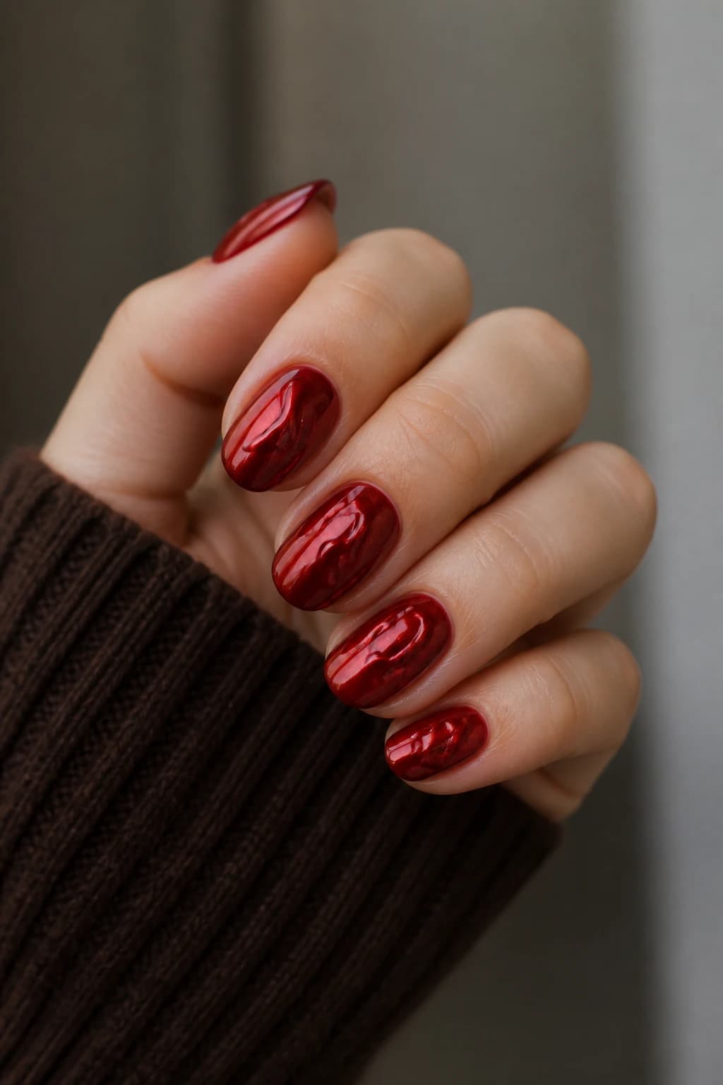 Medium round nails in red with a 3D design and a chrome finish, fall nail design